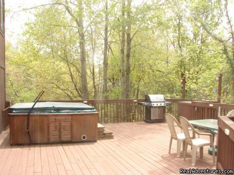 side of deck with grill, hot tub and table | Charming Chalet with HUGE Deck | Image #18/21 | 