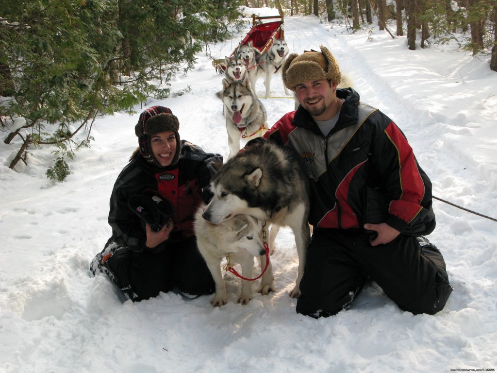 Guests having some cuddle time on the trail | Singing Dogs-Cabin Rentals | Image #6/6 | 