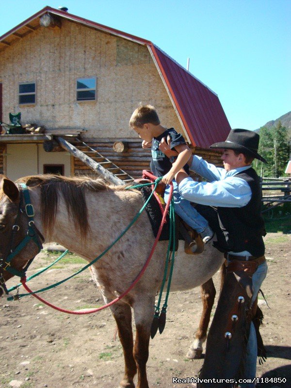 Wrangler assists a young rider | Hawley Mountain Guest Ranch Vacation | Image #6/16 | 