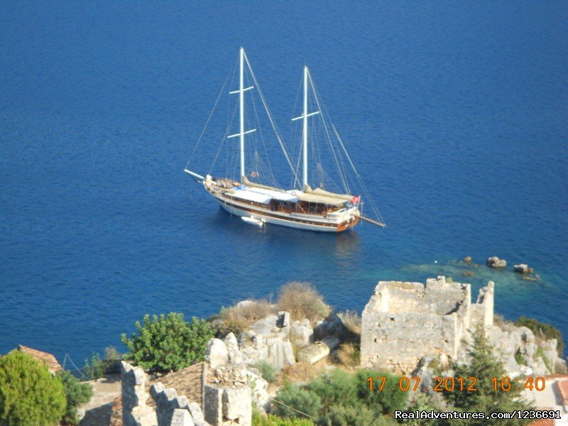Our gulet boat in front of medieval Castle of Simena. | Blue Cruise in Turkey | Fethiye, Turkey | Archaeology | Image #1/18 | 