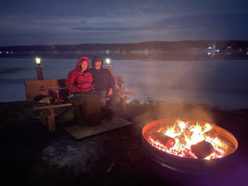 Guests Enjoying Fire | Cozy log cabin feel at Bear Lake Getaway | Image #2/6 | 